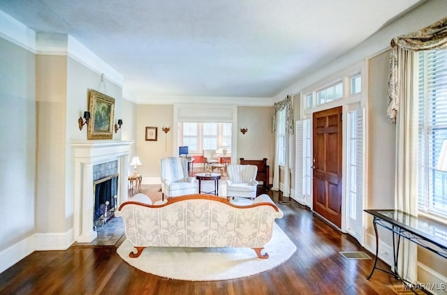 living room with crown molding, dark hardwood / wood-style flooring, and a premium fireplace