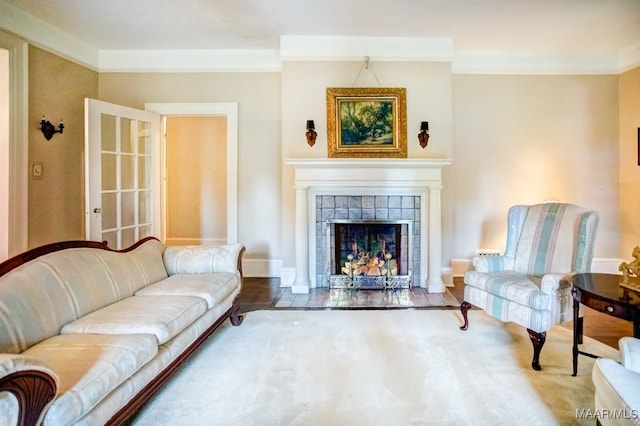 living room featuring ornamental molding, wood-type flooring, and a fireplace