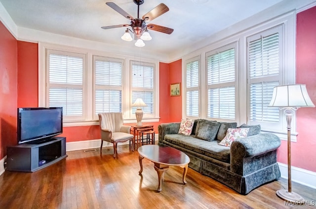 living room featuring wood-type flooring, ceiling fan, and a wealth of natural light