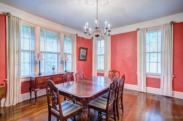 dining area with dark hardwood / wood-style flooring and a chandelier