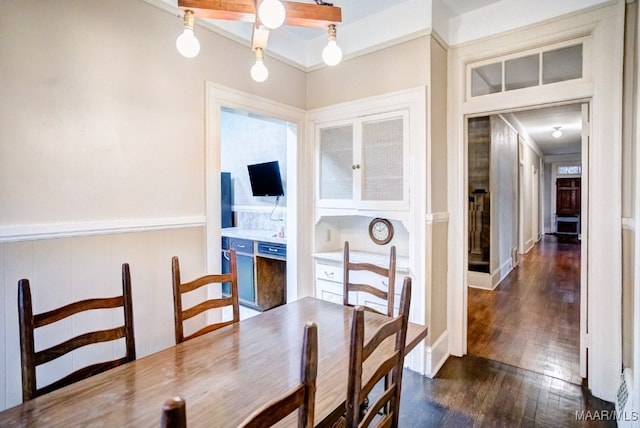 dining area featuring crown molding and dark wood-type flooring