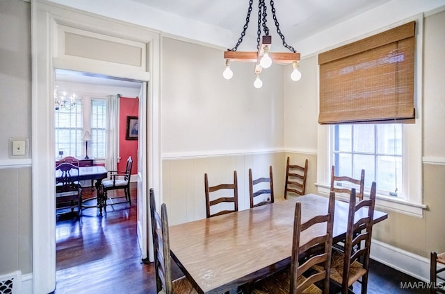 dining area with a notable chandelier, dark hardwood / wood-style floors, and a wealth of natural light