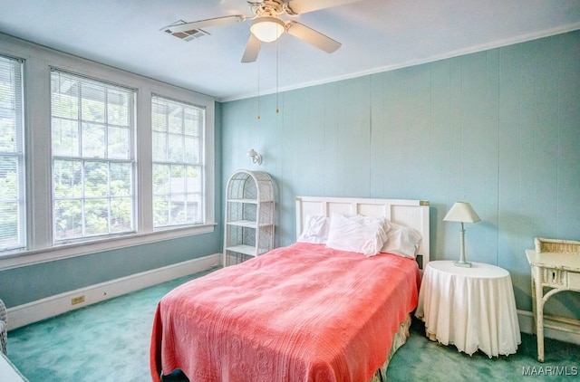 carpeted bedroom with ornamental molding and ceiling fan