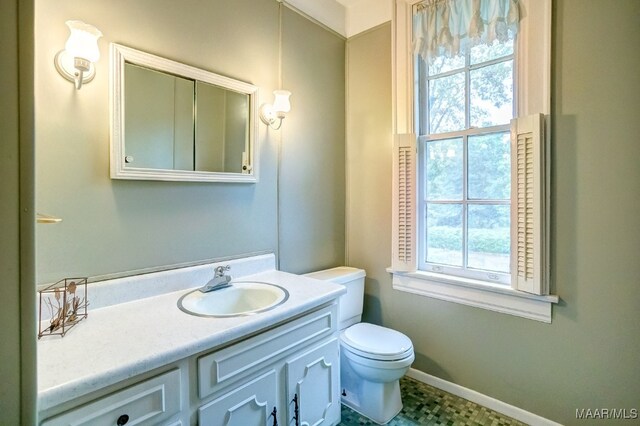 bathroom with vanity, toilet, and a wealth of natural light