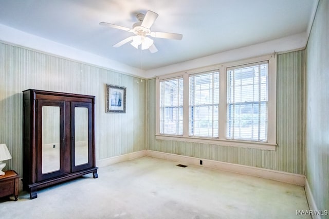 spare room featuring ceiling fan and light colored carpet