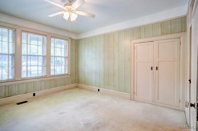 carpeted spare room featuring ceiling fan