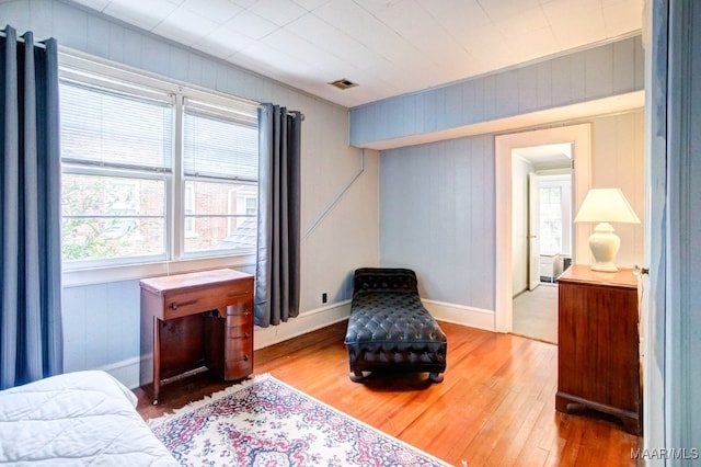 sitting room with wood-type flooring and wooden walls