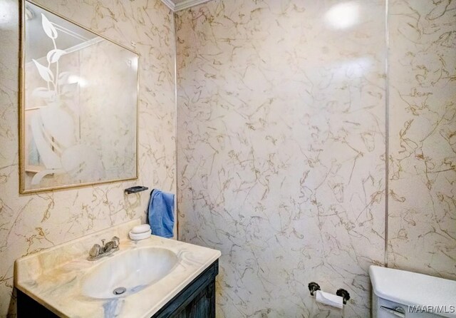 bathroom with ornamental molding, vanity, and toilet