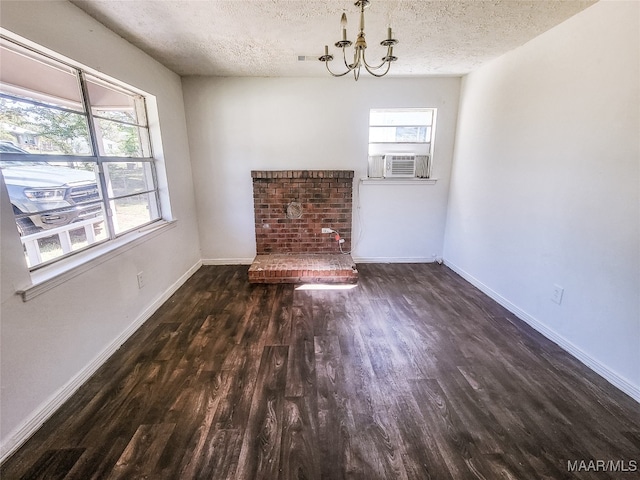 unfurnished living room with cooling unit, a chandelier, a textured ceiling, and dark hardwood / wood-style flooring