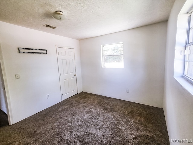 unfurnished bedroom featuring carpet floors and a textured ceiling