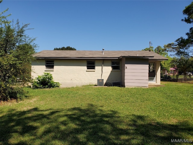 back of house with central AC and a yard