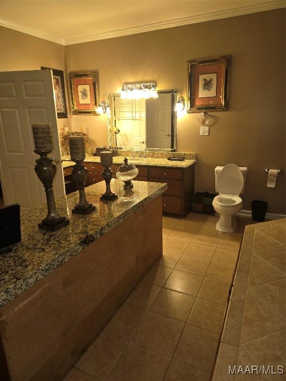 bathroom featuring tile patterned flooring, ornamental molding, and toilet