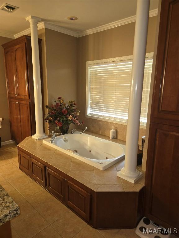 bathroom featuring ornamental molding, tile patterned floors, decorative columns, and a bathtub