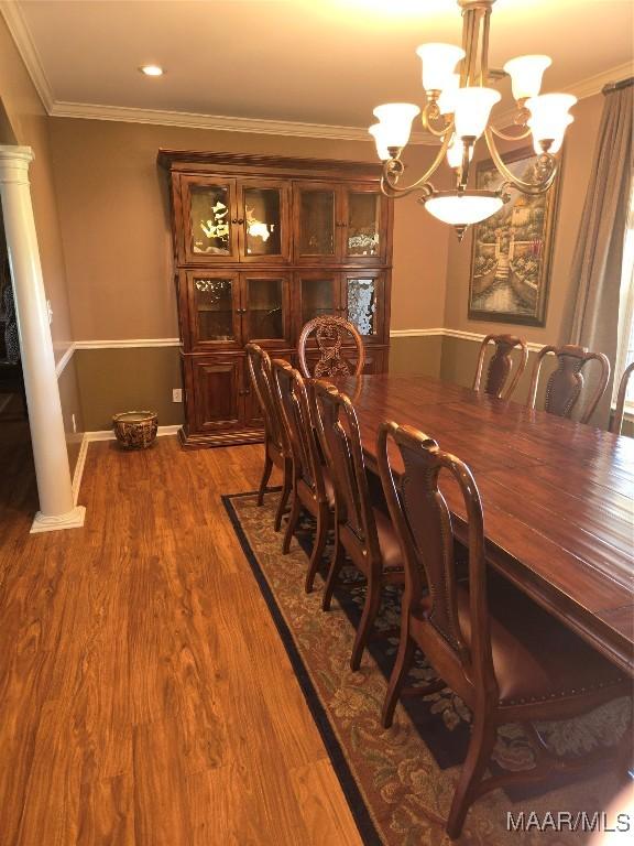 1715 County Road 2203rd Rd, Goshen, AL 36035 - dining area with baseboards, ornamental molding, decorative columns, dark wood-type flooring, and a notable chandelier
