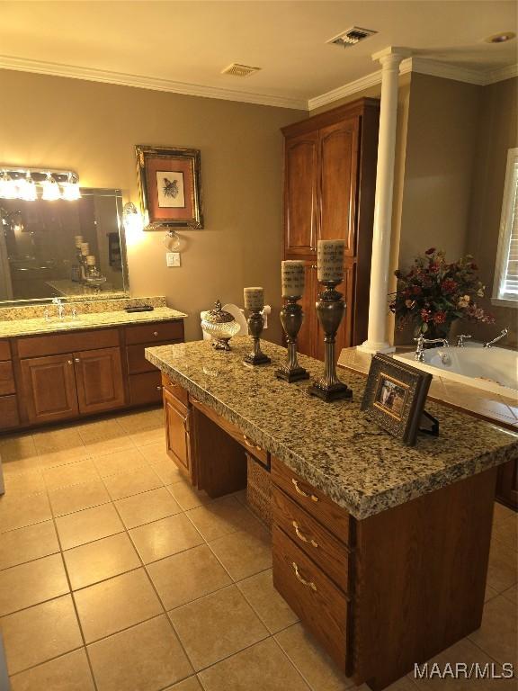 bathroom featuring a bath, tile patterned floors, crown molding, vanity, and ornate columns