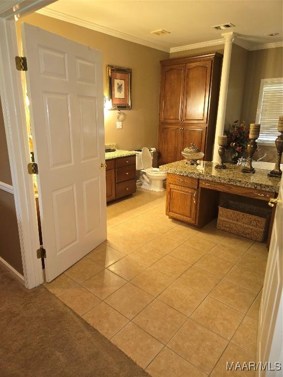 bathroom featuring toilet, tile patterned floors, ornamental molding, vanity, and ornate columns