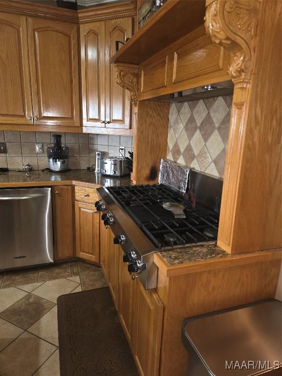 1715 County Road 2203rd Rd, Goshen, AL 36035 - kitchen with light tile patterned flooring, backsplash, gas stovetop, stainless steel dishwasher, and brown cabinetry