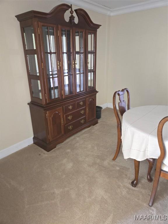 dining area with light colored carpet and crown molding