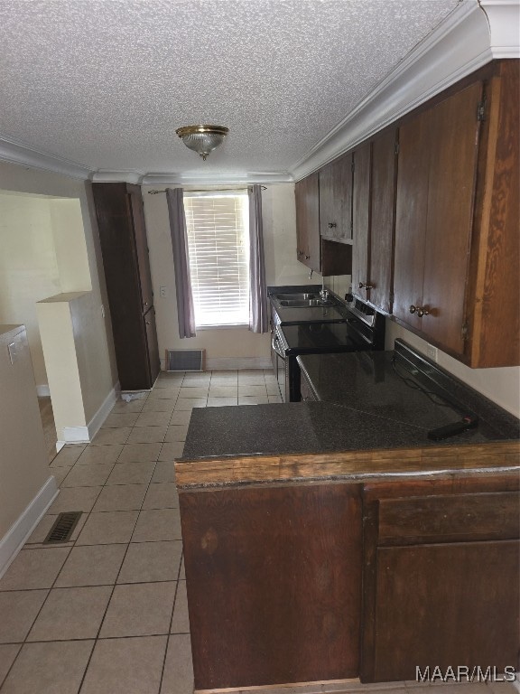 kitchen with stainless steel range with electric cooktop, light tile patterned flooring, dark brown cabinetry, and ornamental molding