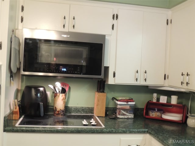 kitchen featuring black electric cooktop and white cabinets