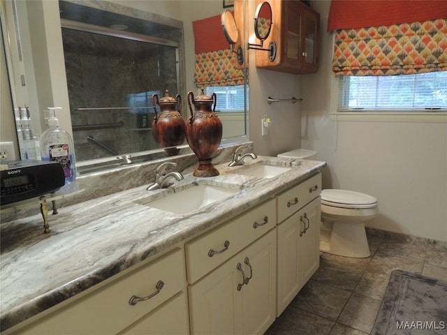 bathroom featuring vanity, toilet, tile patterned flooring, and a shower with door