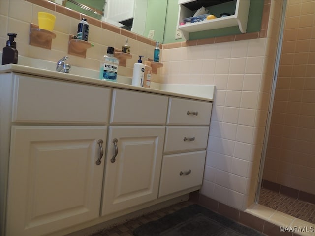 bathroom featuring a shower with door, vanity, tile walls, and backsplash