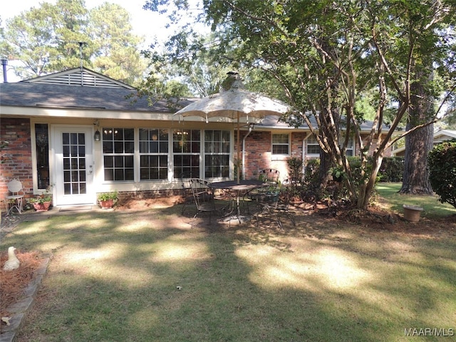 back of property featuring a lawn