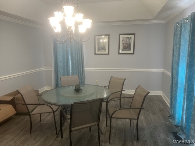 dining space with ornamental molding, an inviting chandelier, and dark hardwood / wood-style floors