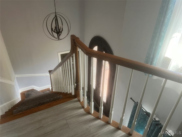 stairway featuring hardwood / wood-style floors and a chandelier