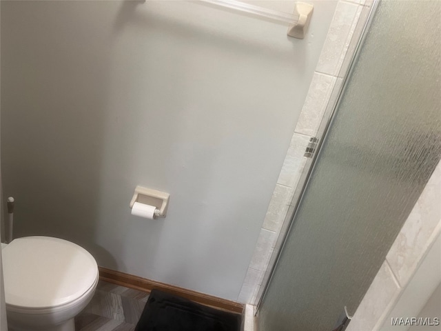 bathroom with toilet and an enclosed shower