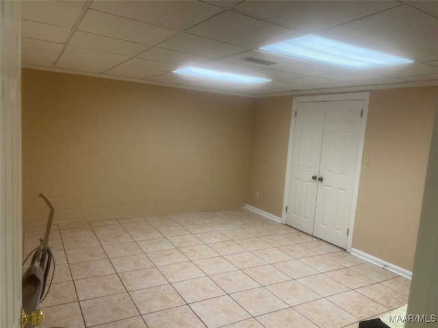 tiled empty room with a drop ceiling