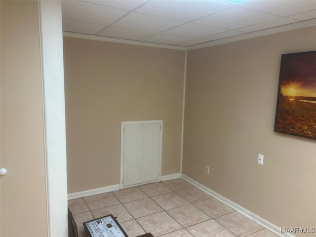 tiled spare room featuring a drop ceiling