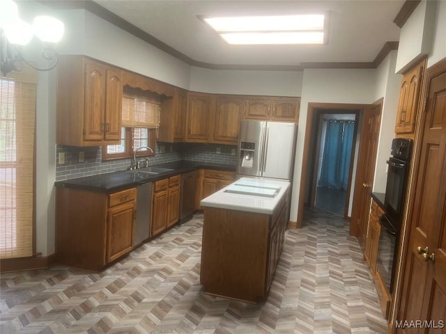 kitchen with a center island, tasteful backsplash, appliances with stainless steel finishes, brown cabinetry, and a sink