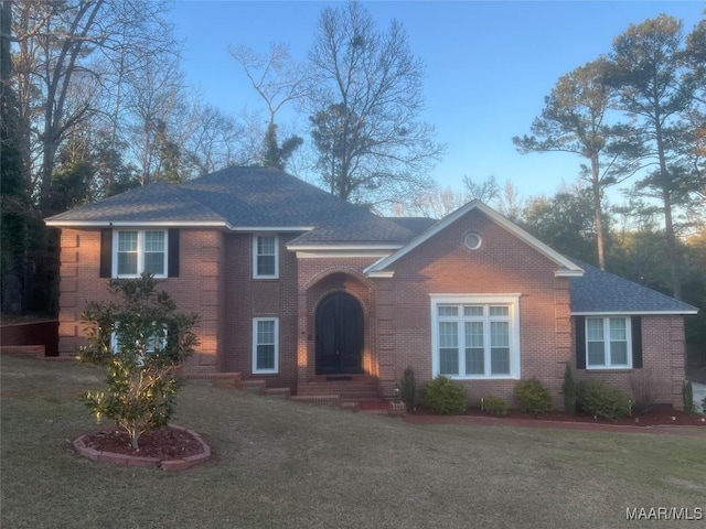 view of front of home featuring brick siding and a front lawn