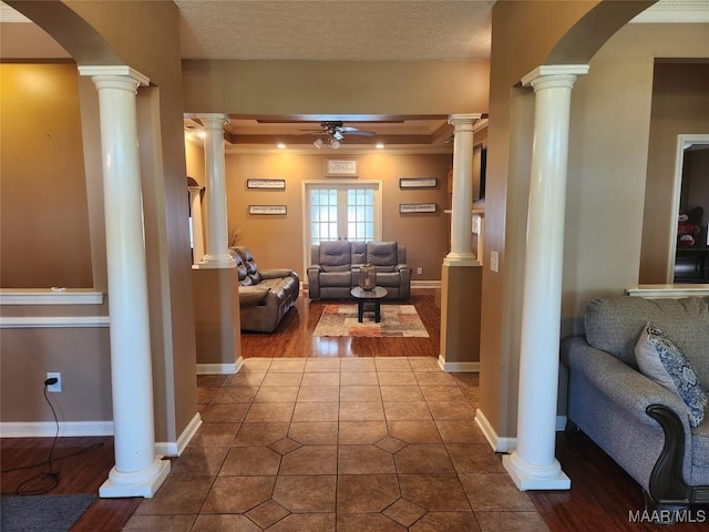 hallway with tile patterned flooring, a textured ceiling, and ornamental molding