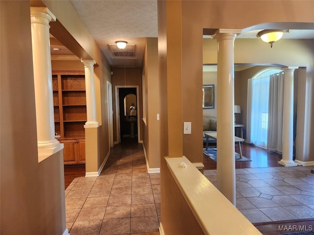 corridor featuring light tile patterned floors and a textured ceiling