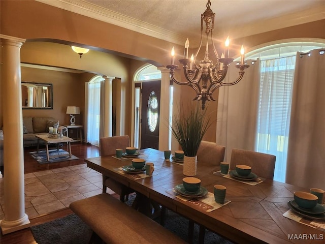 dining room with ornamental molding, a healthy amount of sunlight, and a notable chandelier