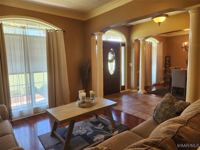 foyer entrance with ornate columns, hardwood / wood-style floors, and ornamental molding