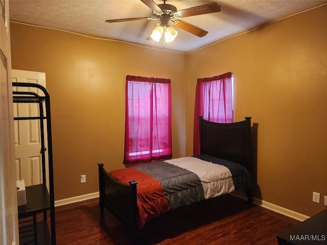 bedroom featuring a textured ceiling, ceiling fan, and dark hardwood / wood-style floors