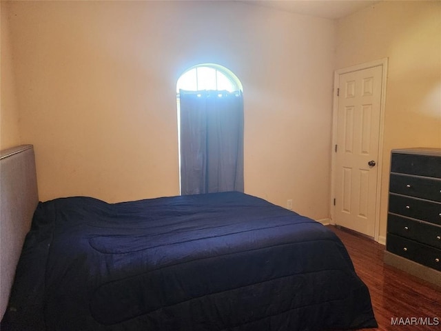 bedroom with dark hardwood / wood-style flooring