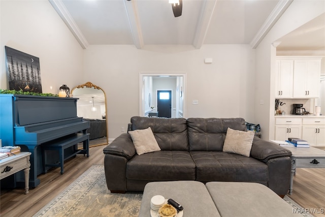 living room featuring ceiling fan, beamed ceiling, light wood-type flooring, and crown molding