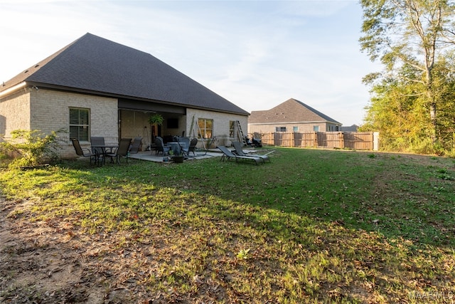 rear view of property featuring a patio and a lawn