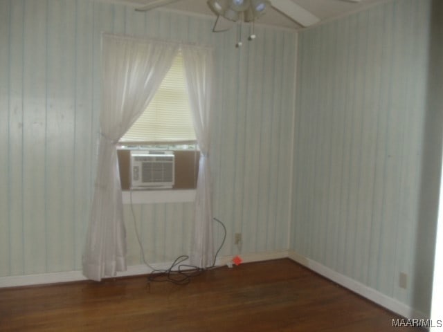 spare room with cooling unit and dark wood-type flooring