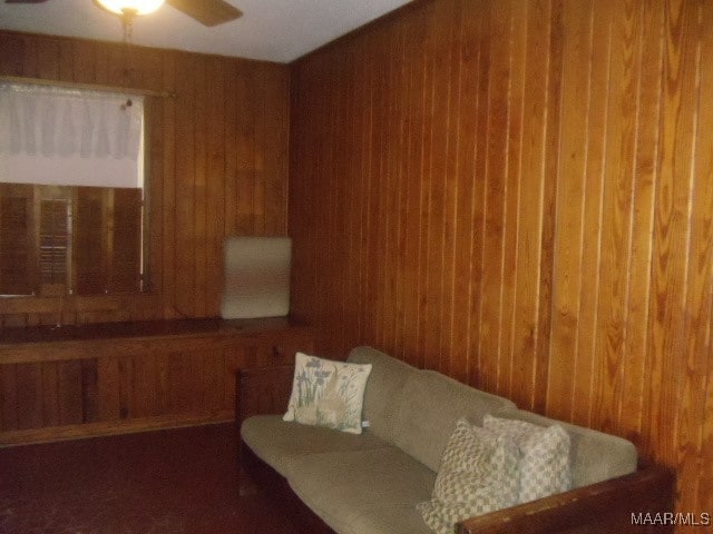 living room with wood walls and ceiling fan