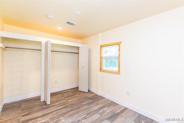 unfurnished bedroom with multiple closets, baseboards, visible vents, and light wood-style flooring