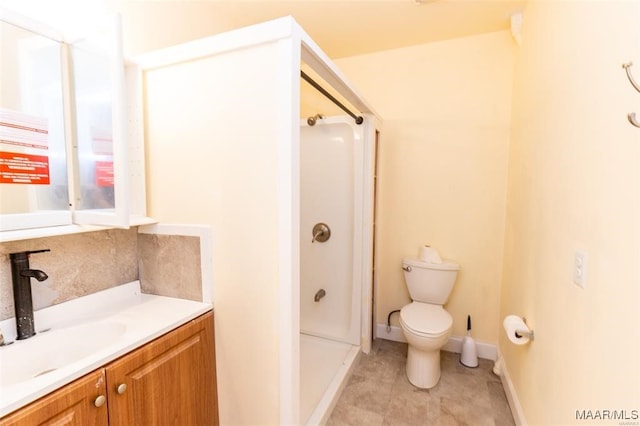 bathroom featuring vanity, a shower, and toilet