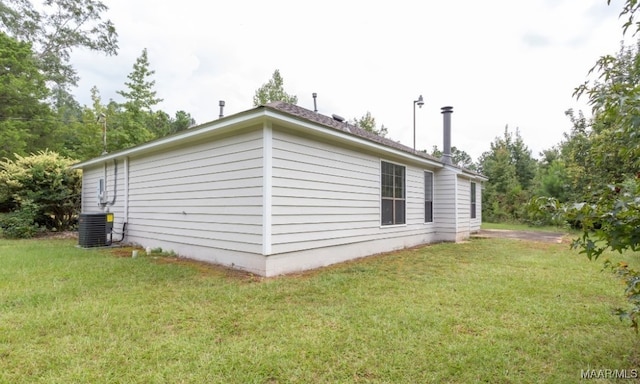 view of property exterior with central air condition unit and a yard