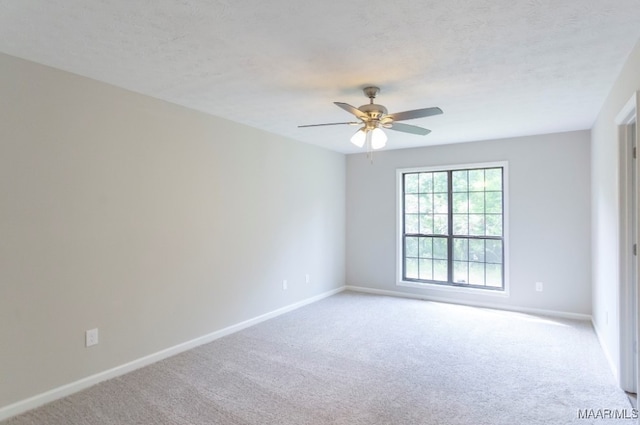 carpeted spare room featuring a textured ceiling and ceiling fan