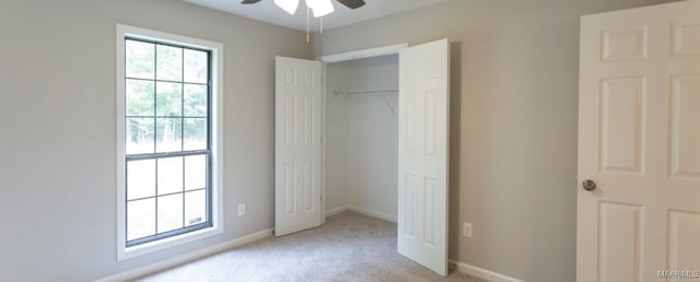 unfurnished bedroom with ceiling fan, a closet, and light carpet