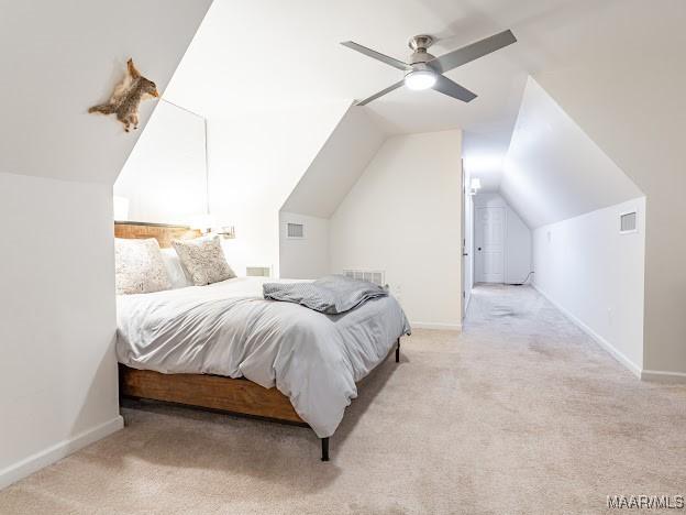 bedroom with visible vents, light colored carpet, and vaulted ceiling